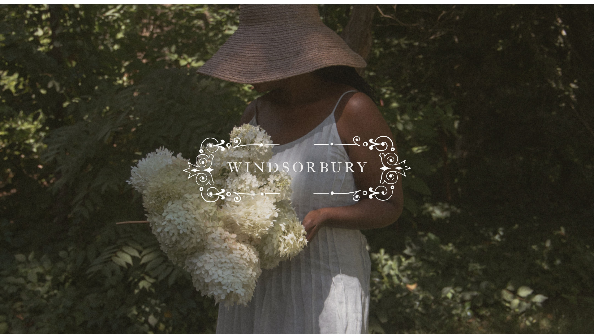 A woman gathering white hydrangeas in the Windsorbury garden